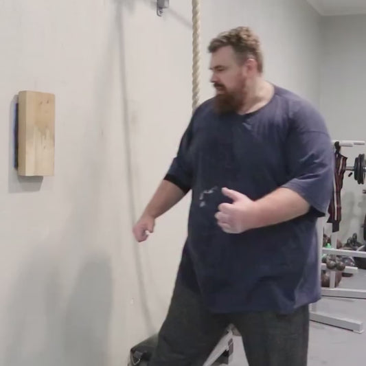 Man Repeatedly Punches Wood Plank with Bare Knuckles