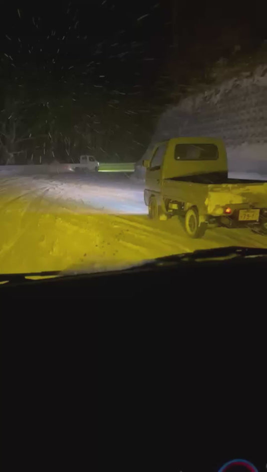Trucks Drift Round Bends on Snowy, Icy Road