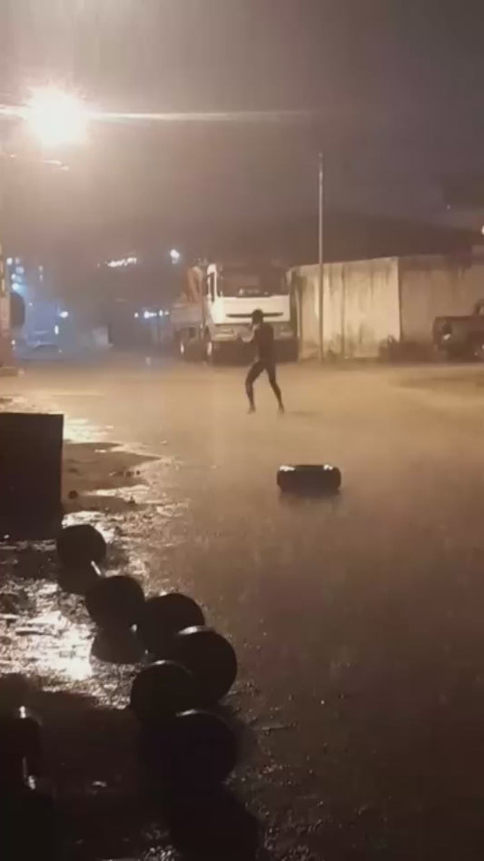 Man Shadow Boxes in the Rain at Night