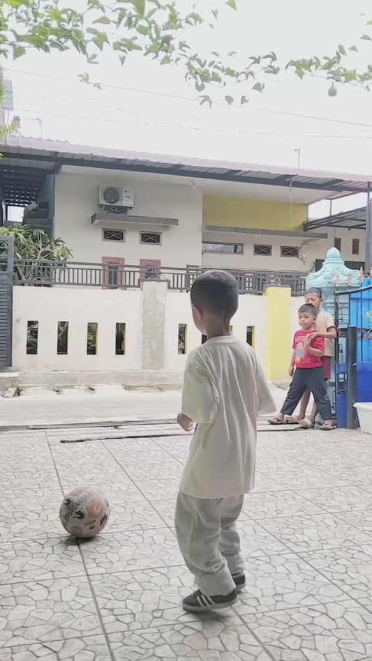 Boy Knocks Ball off Biker Using a Football